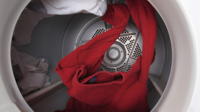 Red and white clothes tumbling inside a dryer