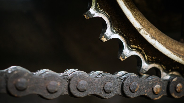 Dirty motorcycle chain and worn sprocket