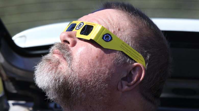 man wearing solar eclipse glasses