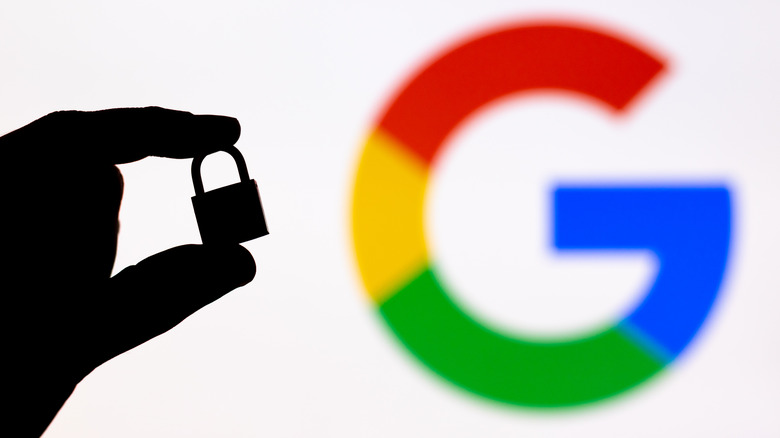 silhouette of person holding lock, blurred Google logo in background
