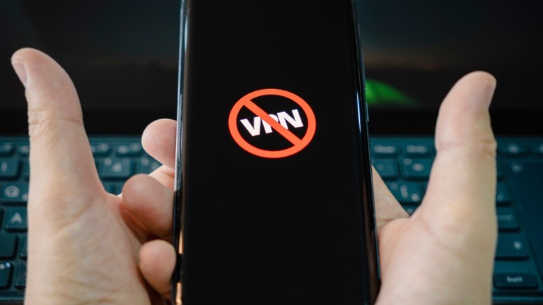 Person holding a phone with a crossed out VPN symbol