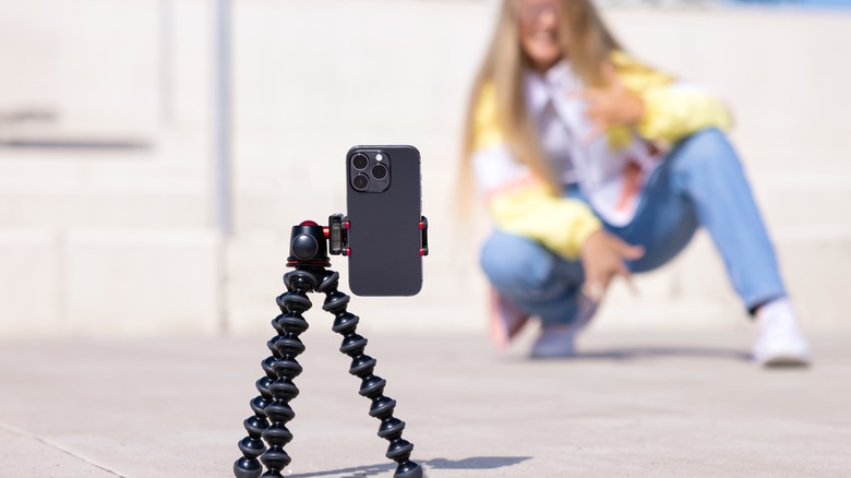 girl posing with iPhone on tripod