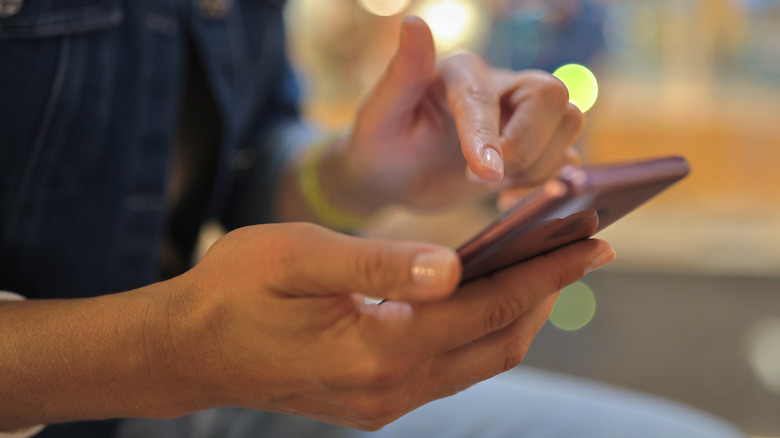 woman tapping on android smartphone