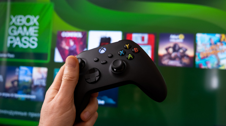 Xbox controller in player's hand with screen in foreground