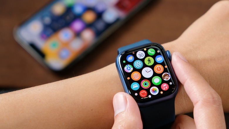 Apple Watch on wrist with iPhone in background