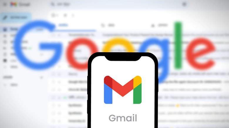 Gmail logo on a smartphone set against a blurred inbox background