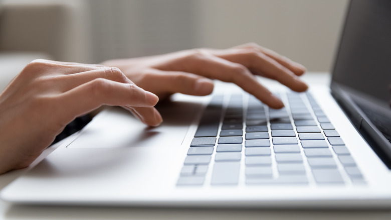 person hands on laptop keyboard