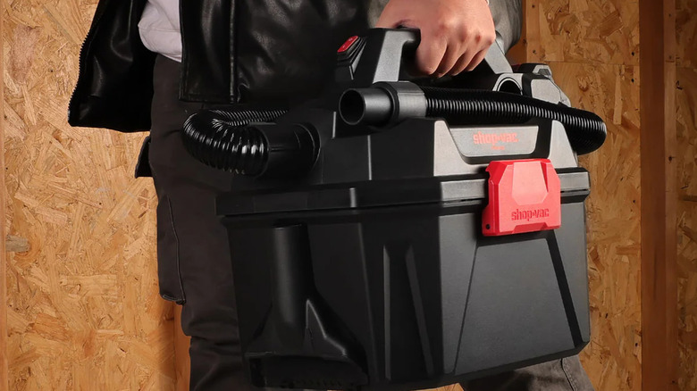 A guy carrying Shop-Vac vaccum