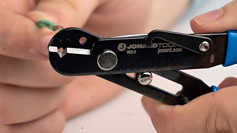 Person removing wire from adjustable wire strippers