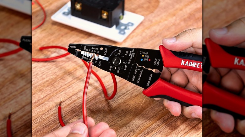 Person inserting wire into gauged wire strippers