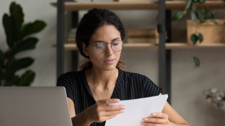 A girl reading a stack of paper.