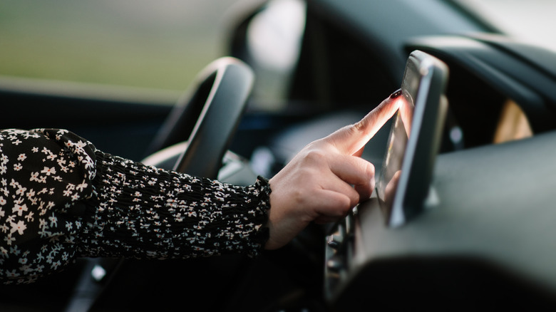 woman touching car navigation screen
