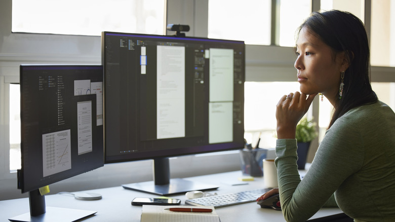 Person using computer setup with two monitors