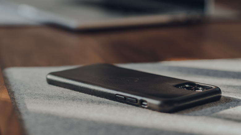 black iPhone turned over on desk
