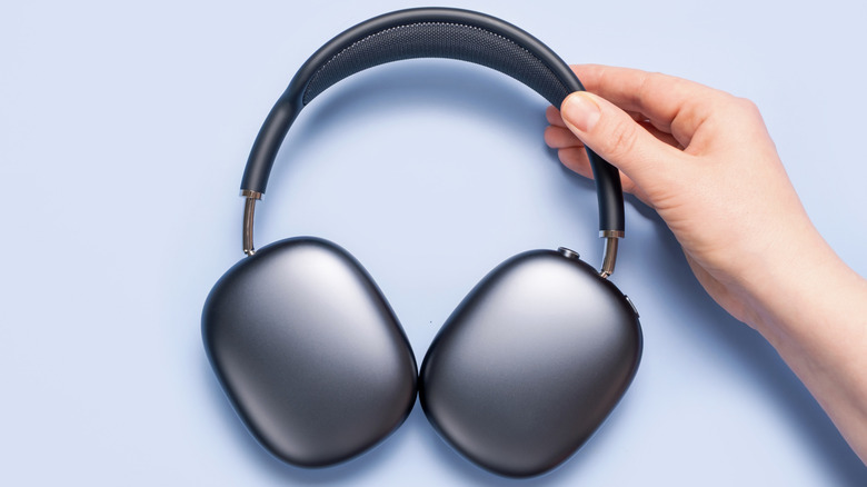 Person holding a pair of AirPods Max