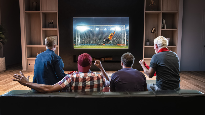 Group watching soccer game on home TV