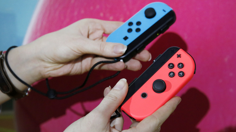 Person holding Joy-Con controllers