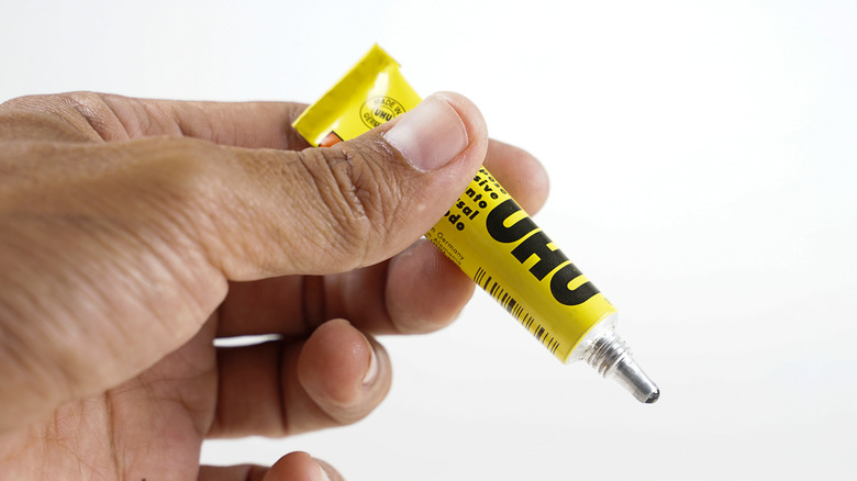person holding tube of super glue