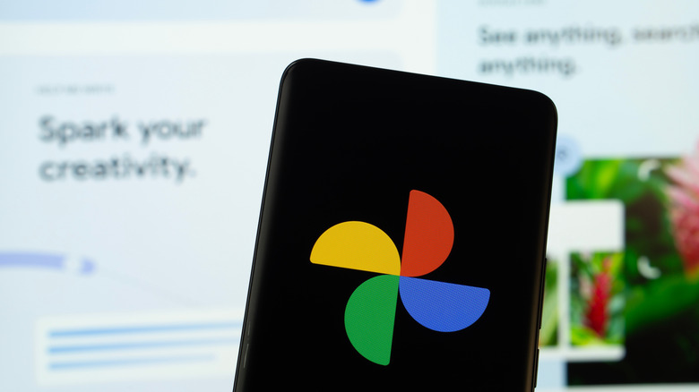Smartphone displays Google Photos logo with web app in background