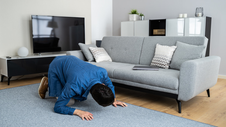 person looking under couch