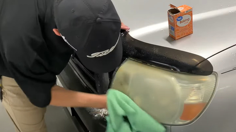 Man using solution to clean headlights