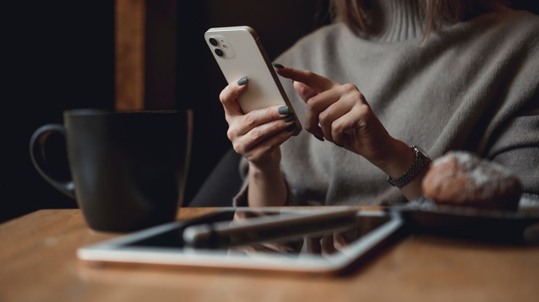 Woman using iPhone coffee shop