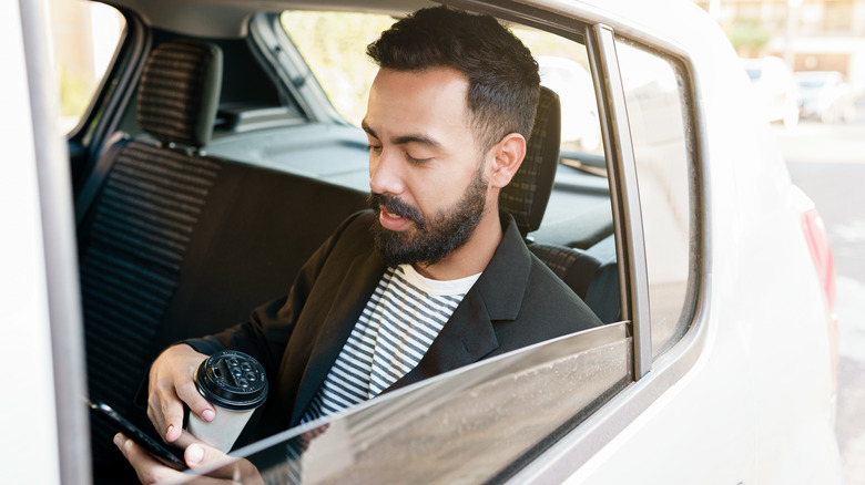 Person using smartphone in car