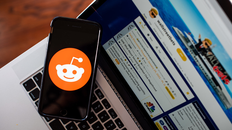 phone on laptop showing Reddit logo