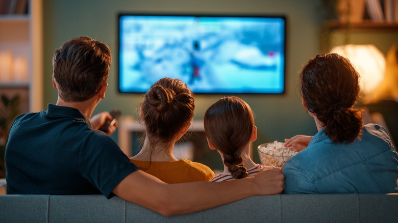 Family watching television together on couch