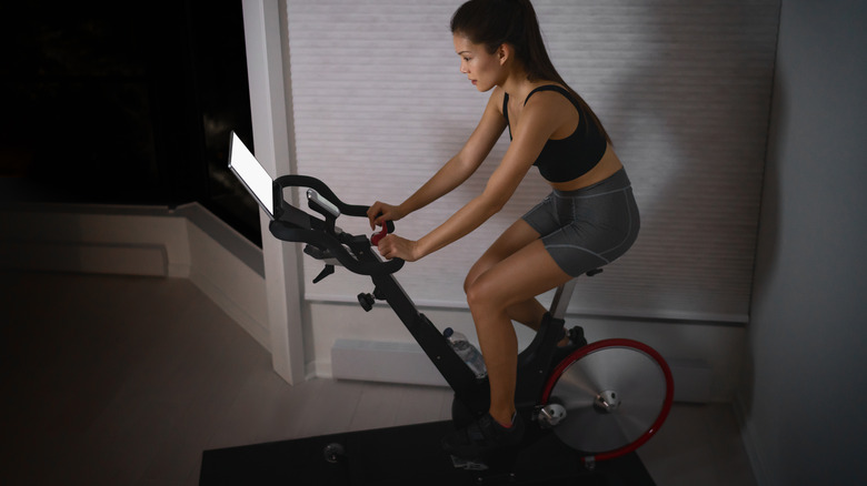 Woman watching Peloton touchscreen