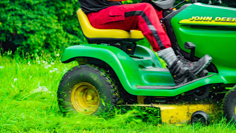 A John Deere riding lawn mower cutting grass