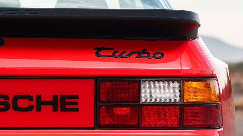 Close-up of "turbo" emblem on red Porsche 944.