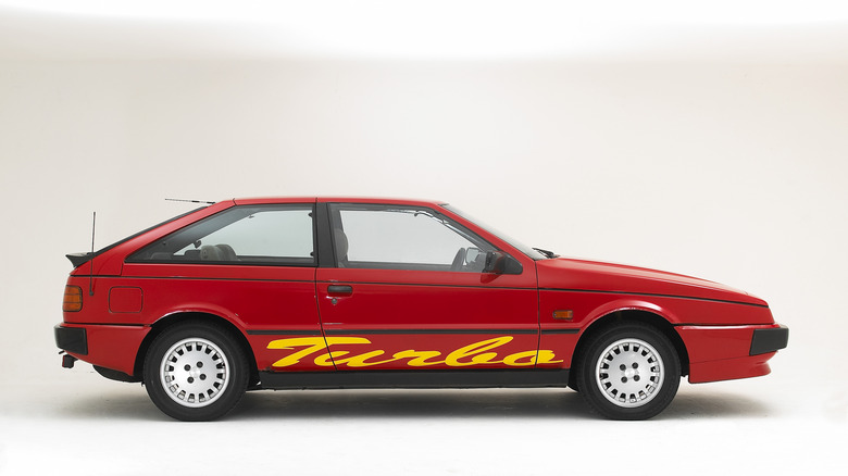 Side view of red Isuzu Piazza with large yellow 