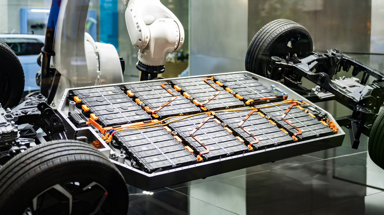 A robotic arm installs a battery pack on an EV chassis