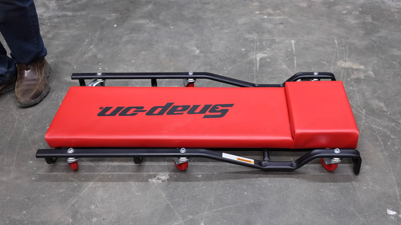 Red Snap-On branded creeper on a workshop floor