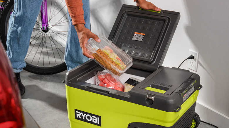 man putting food into Ryobi cooler