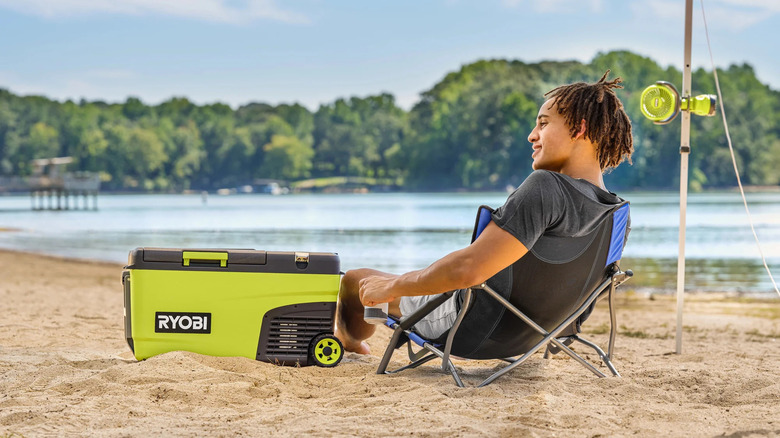 man on beach with Ryobi cooler