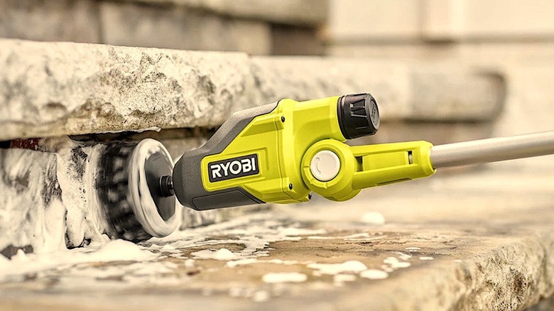 Person cleaning front steps with Ryobi Telescopic Power Scrubber