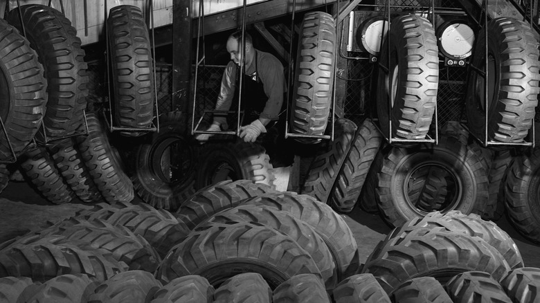 Worker loads tire at tire plant during World War II