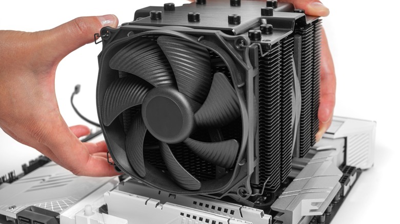 Person holding large black tower style CPU cooler