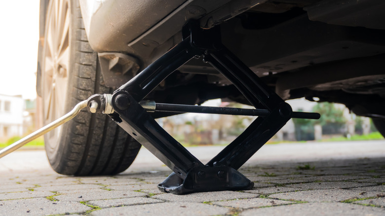Screw jack underneath vehicle