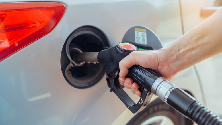 A person filling their car up at the fuel pump