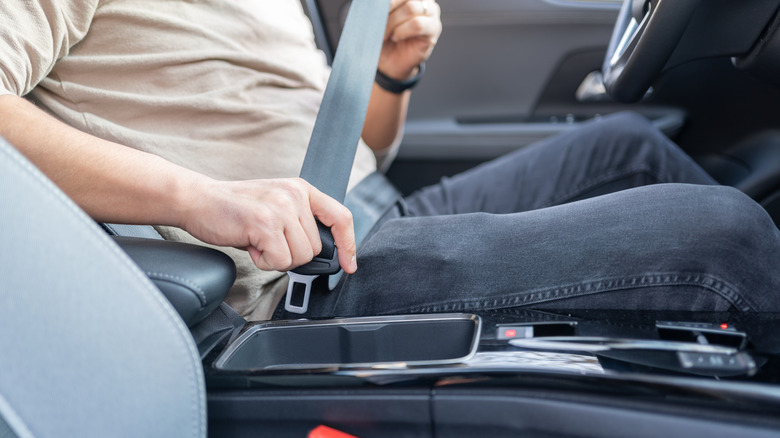 A person fastening their seatbelt