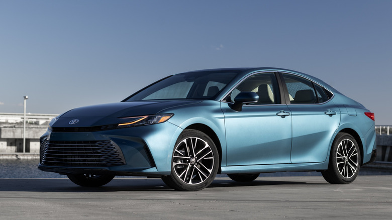 Front 3/4 view of blue 2026 Camry XLE parked on rooftop.
