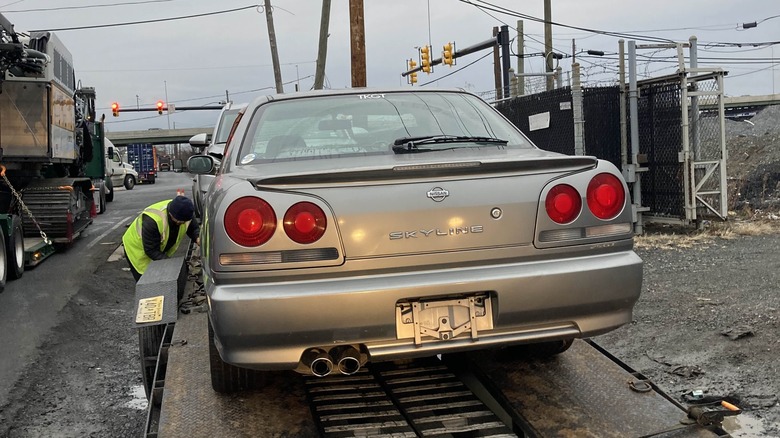 Silver 2000 Nissan Skyline 4-door parked on a trailer