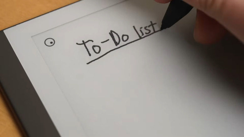 A person writing on an e-ink tablet