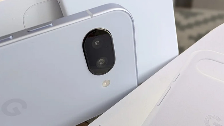 A Google Pixel 9a on its side next to its original packaging