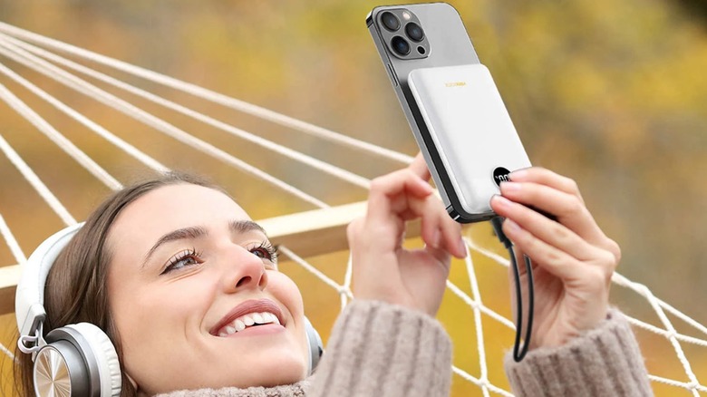 Person using a VEEKTOMX power bank to charge their phone