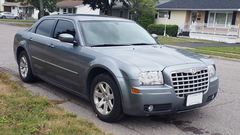 gray first generation Chrysler 300 parked on a residential road