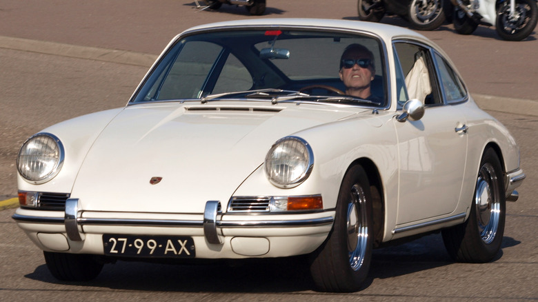 A white 1965 Porsche 911 on the road at a festival in the Netherlands, circa 2009